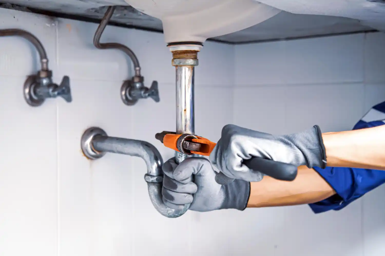 Emergency plumber repairing a detected water leak to prevent property damage