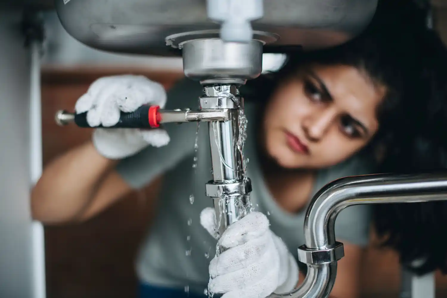 Skilled emergency plumber repairing burst pipes and fixing water damage in a home