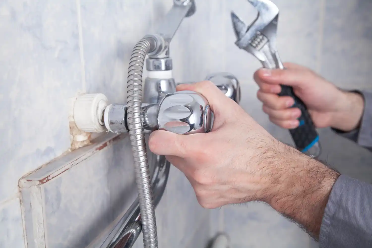 Professional plumber rerouting pipes and installing plumbing connections for a new shower