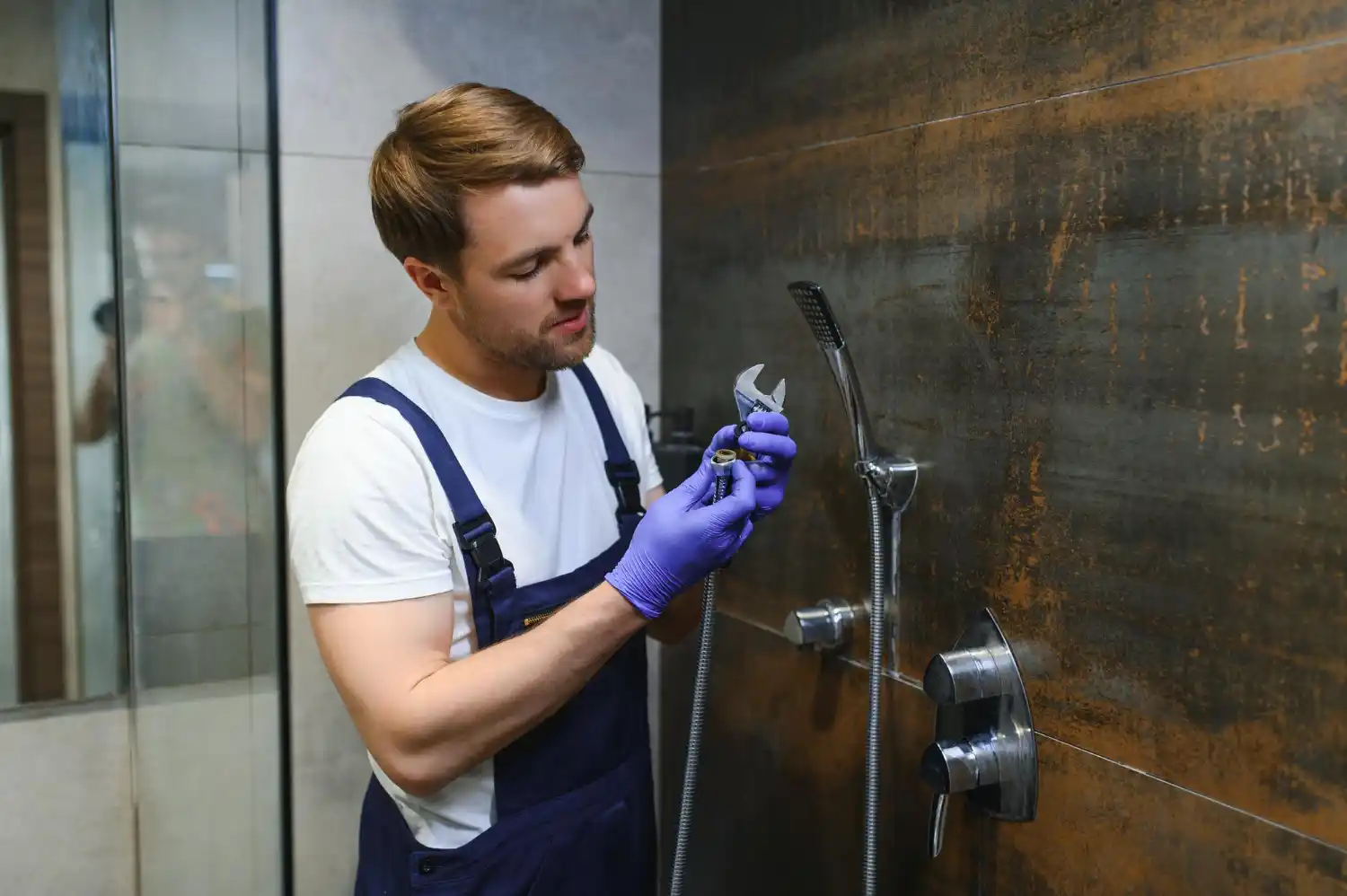 Professional shower installer preparing plumbing connections and waterproof shower base